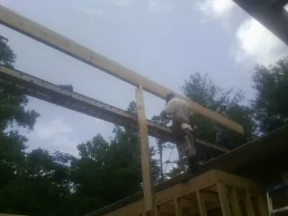Carpenter setting a ridge beam over a new addition frame — Ice Dam Removal by Roofing Brothers in Lanexa