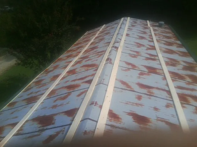 Rusted metal roof panels with new wood purlins before replacement — Storm Damage Roof Repair in Lanexa by Roofing Brothers